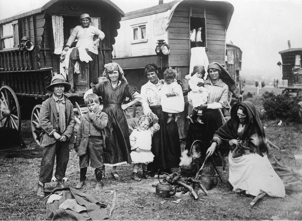 A black and white photo of a Roma camp and wagon on the beach in England