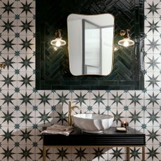 Tiles with a star pattern on and brik tiles in a herringbone pattern around a mirror
