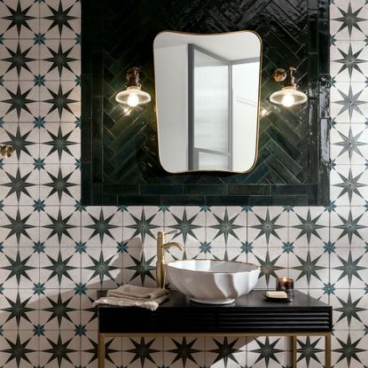 Tiles with a star pattern on and brik tiles in a herringbone pattern around a mirror