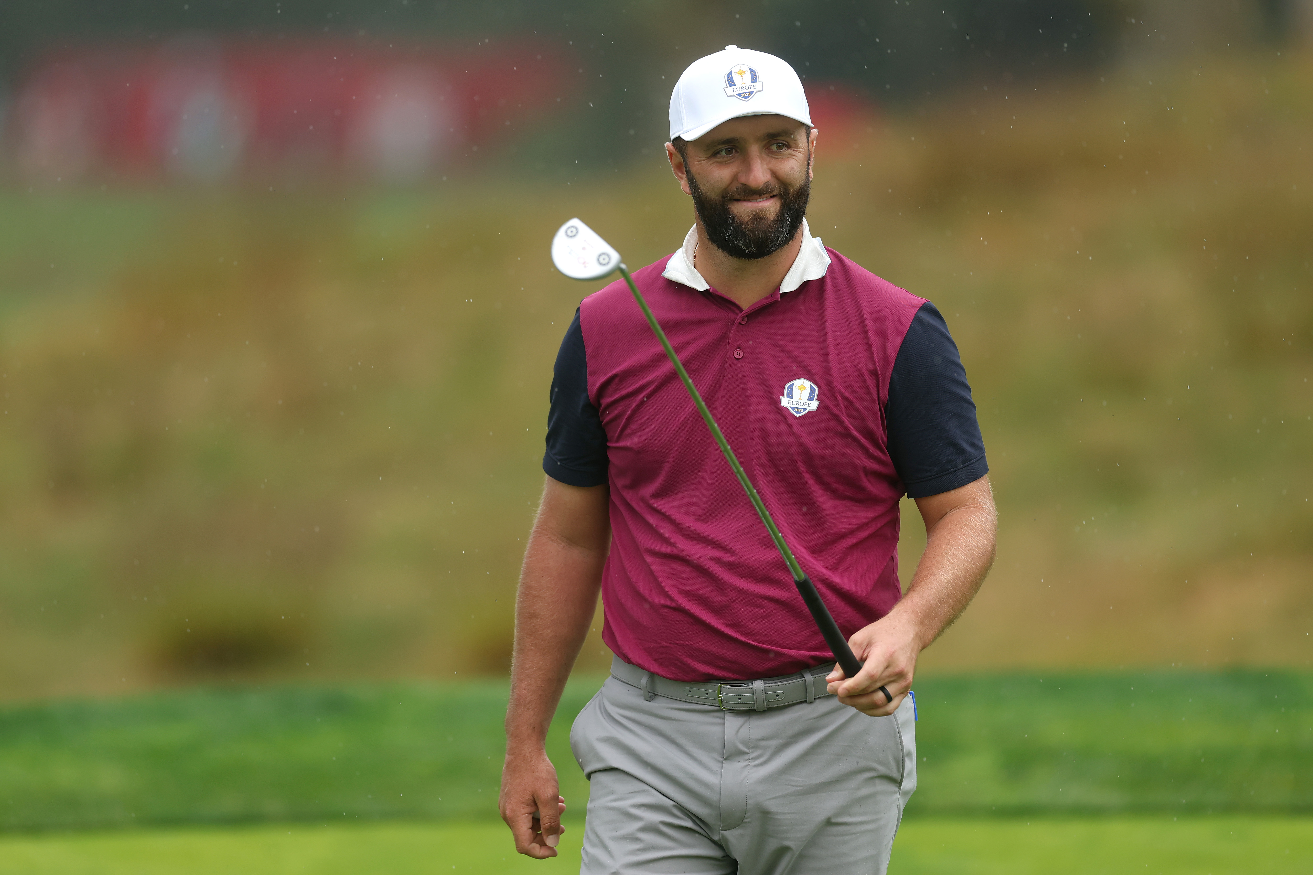Jon Rahm raises his putter in the air