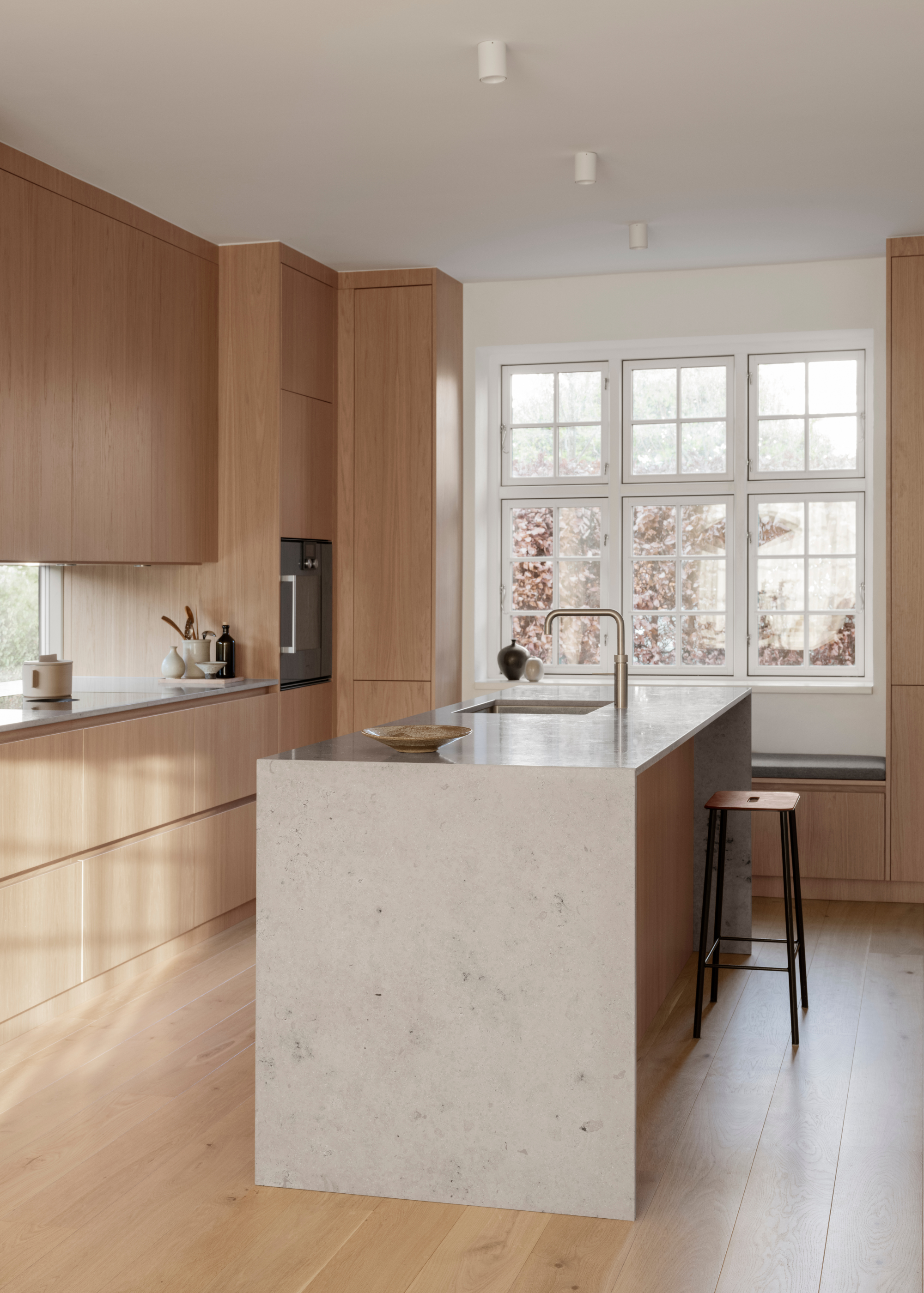 light oak kitchen with light stone waterfall island