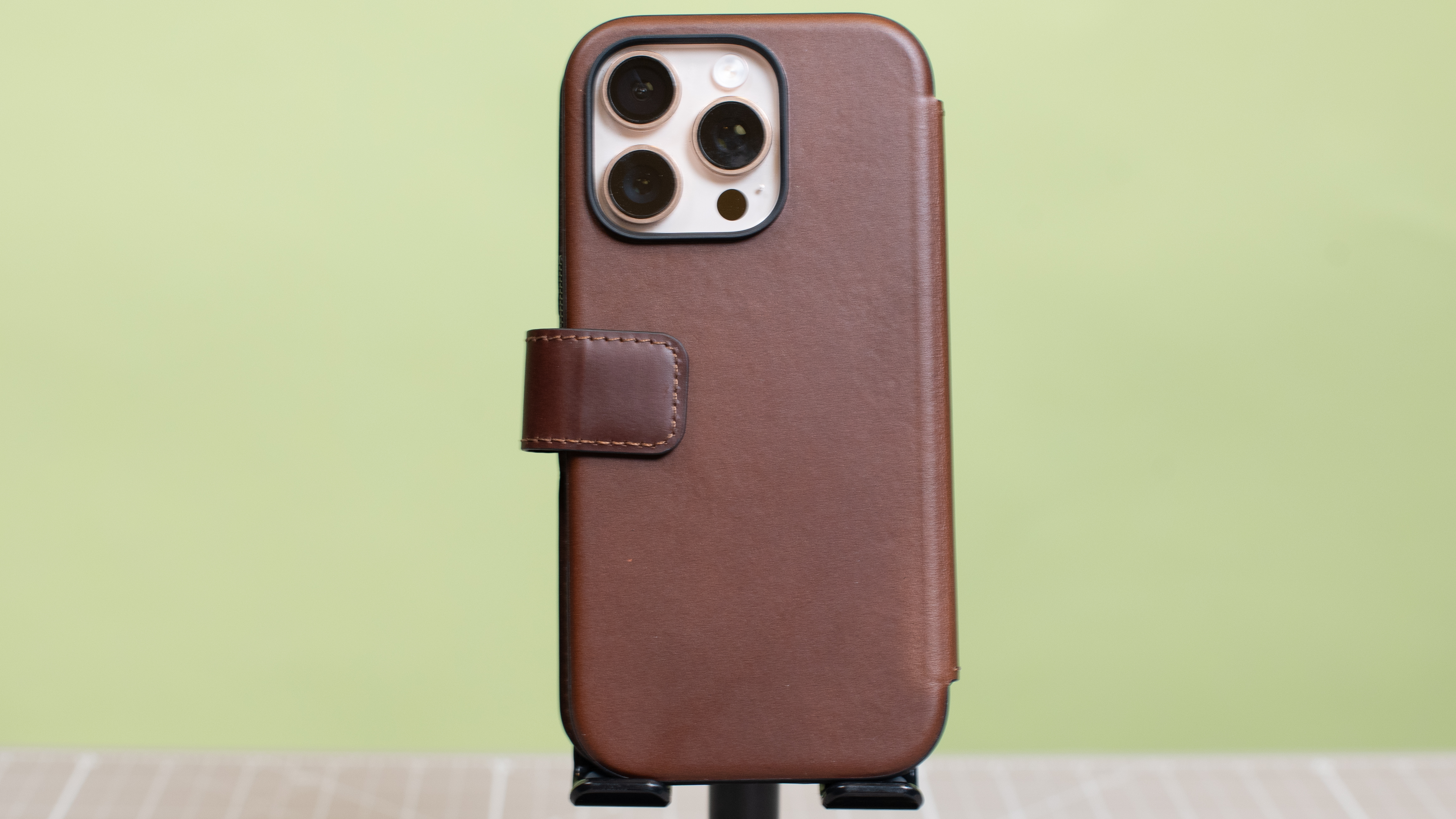 Nomad modern leather folio with iPhone 16 Pro in desert titanium inside showing multiple angles and buttons and camera cutout hole