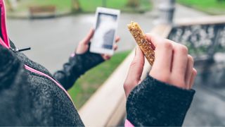 Woman holding energy bar while on a run