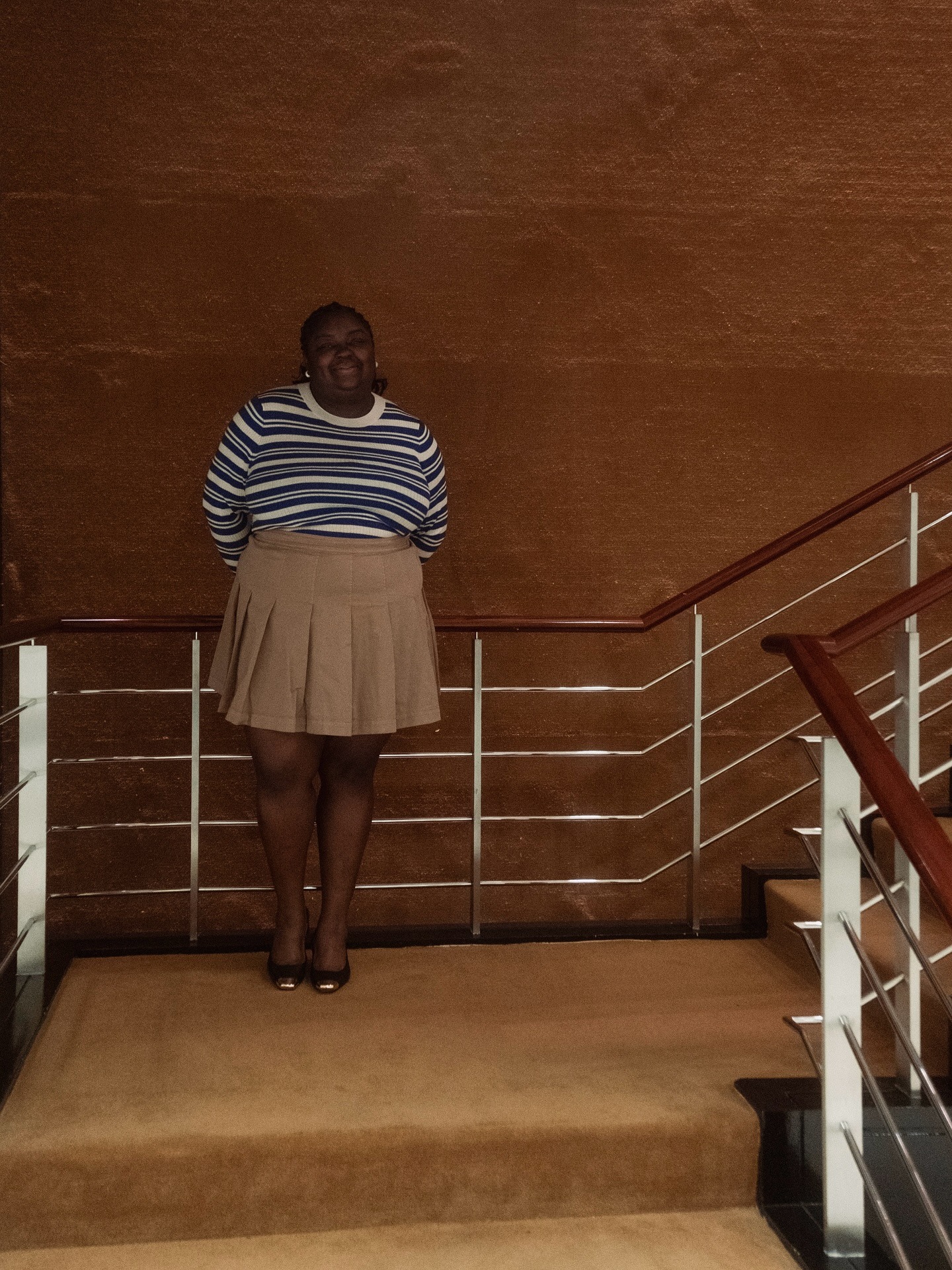 Abi wears a striped sweater and khaki skirt.