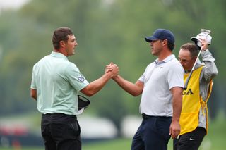 Bryson DeChambeau and Brooks Koepka shake hands on the 18th green