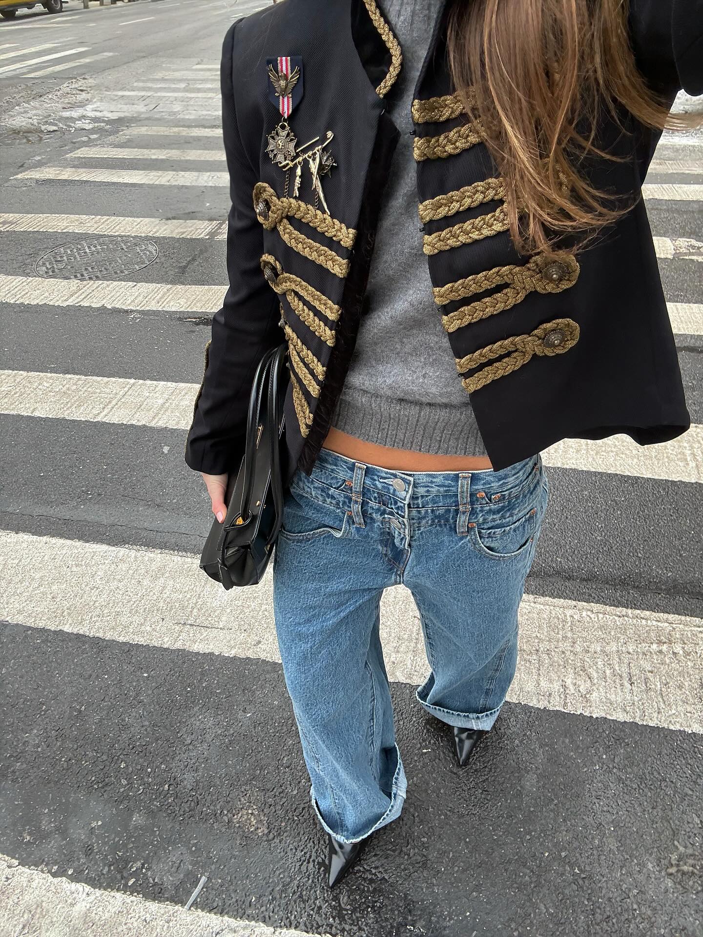 Hannah Lovey wears a military jacket, grey sweater and jeans