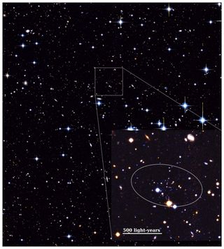 A false-color image taken with MegaCam on the Canada-France-Hawaii Telescope (CFHT) as part of the Pan-Andromeda Archaeological Survey (PAndAS) shows a large swath of black space dotted with blue and yellow stars of various brightness. Toward the center of the image, an inset highlights a small cluster of faint spots, revealing where Andromeda XXXV is located.