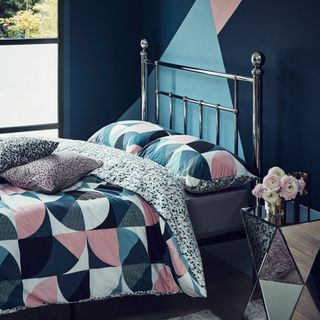 bedroom with printed blue bedding set and walls