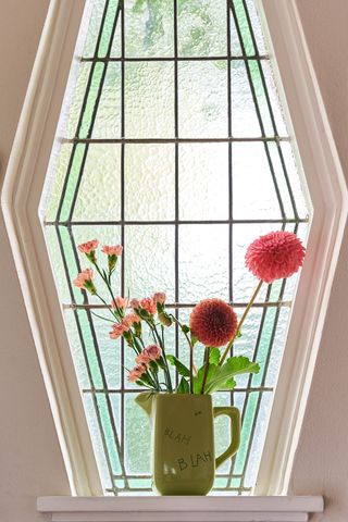 A vase of dahlias on a window sill