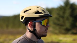 Oakley ARO3 helmet worn by a man in sunglasses, side on in Matte Curry color