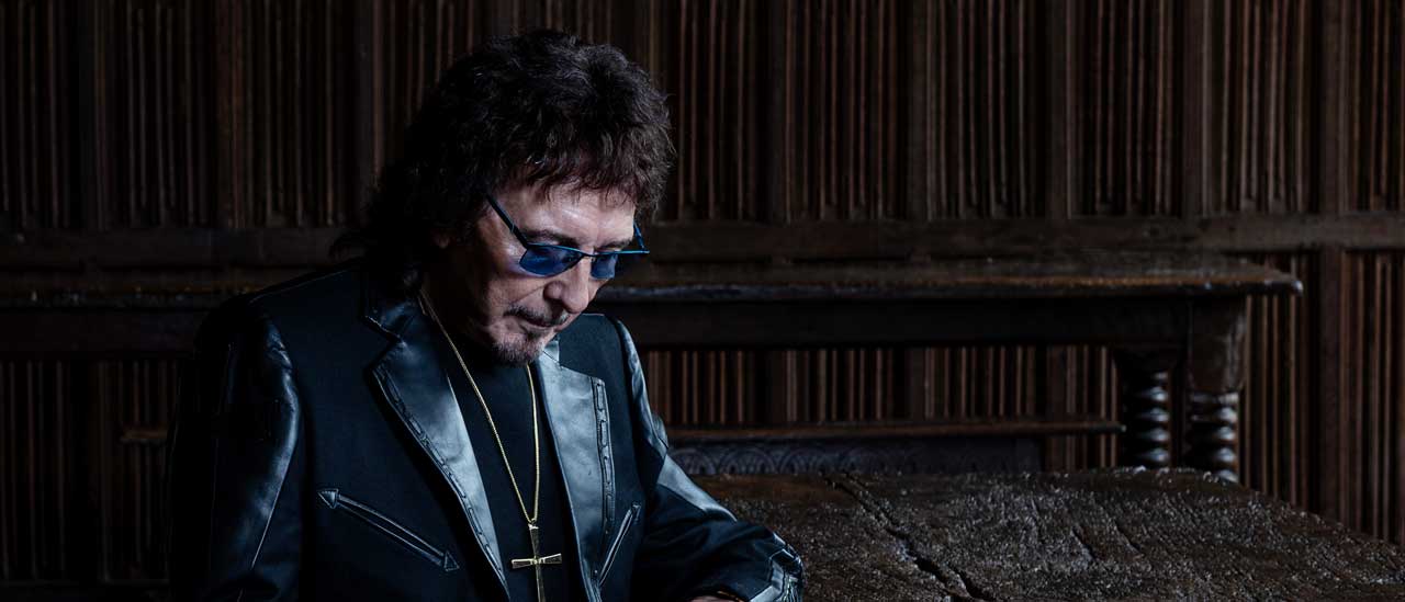 Tony Iommi with guitar in a dark room