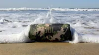 The JBL Charge 5 rocked by an ocean wave