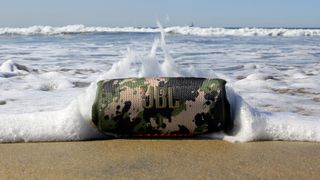 best waterproof speakers: JBL Charge 5 rocked by an ocean wave