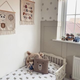 A children's bedroom with wall panelling painted in Egyptian Cotton by Dulux and the wall above covered in polka dots