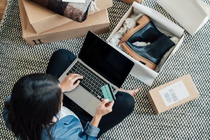 High angle view of a young Asian woman shopping online on laptop, making payment with credit card. Enjoying Seasonal sales