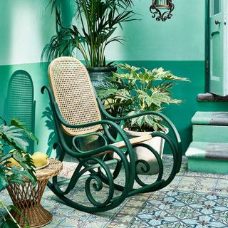 Vintage rocking chair in a green conservatory with patterned floor tiles and painted in Provence Florence Amsterdam by Annie Sloan