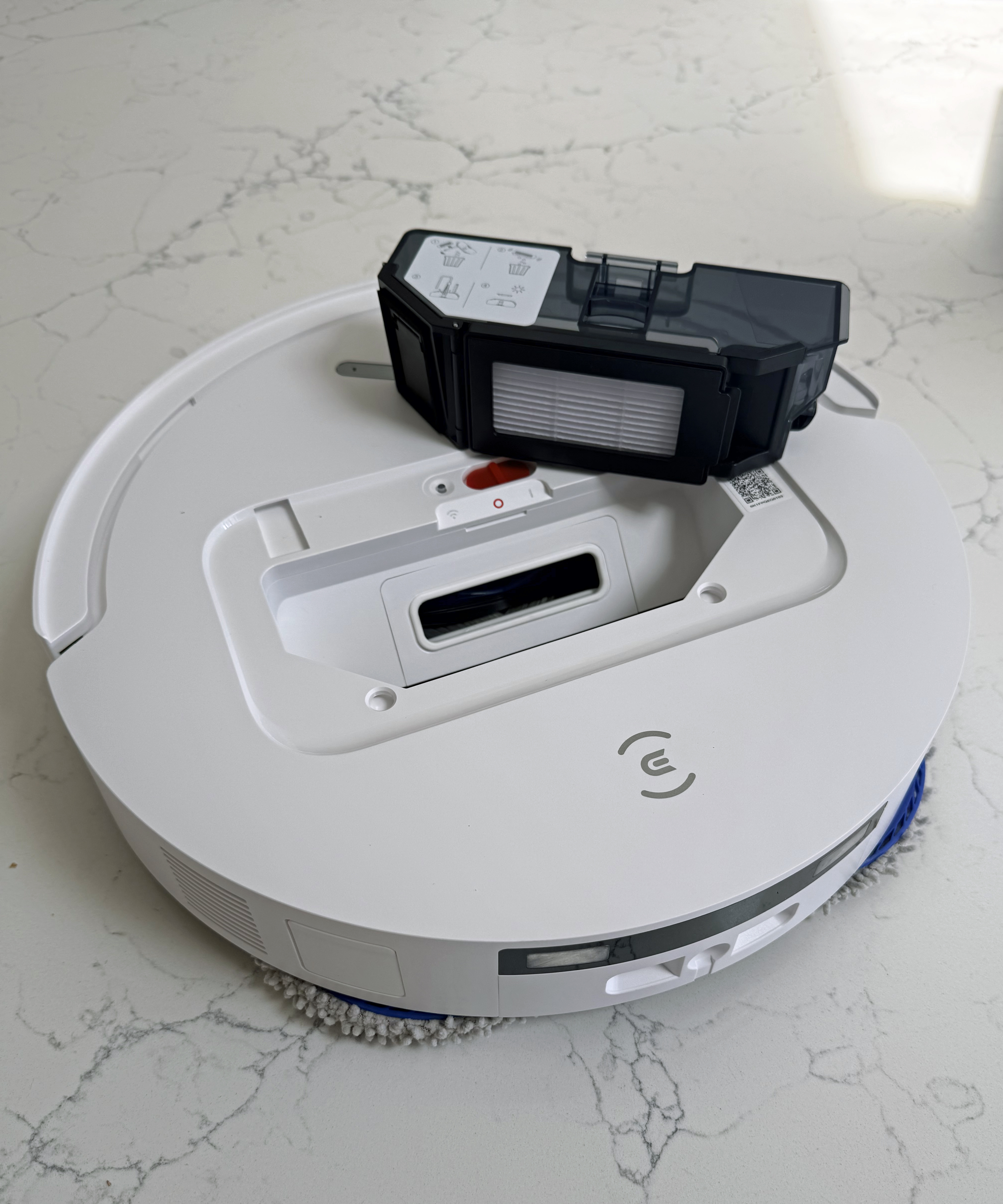 Top of the Ecovacs Deebot T50 Pro Omni robot vacuum with the dustbin compartment open and the dustbin removed