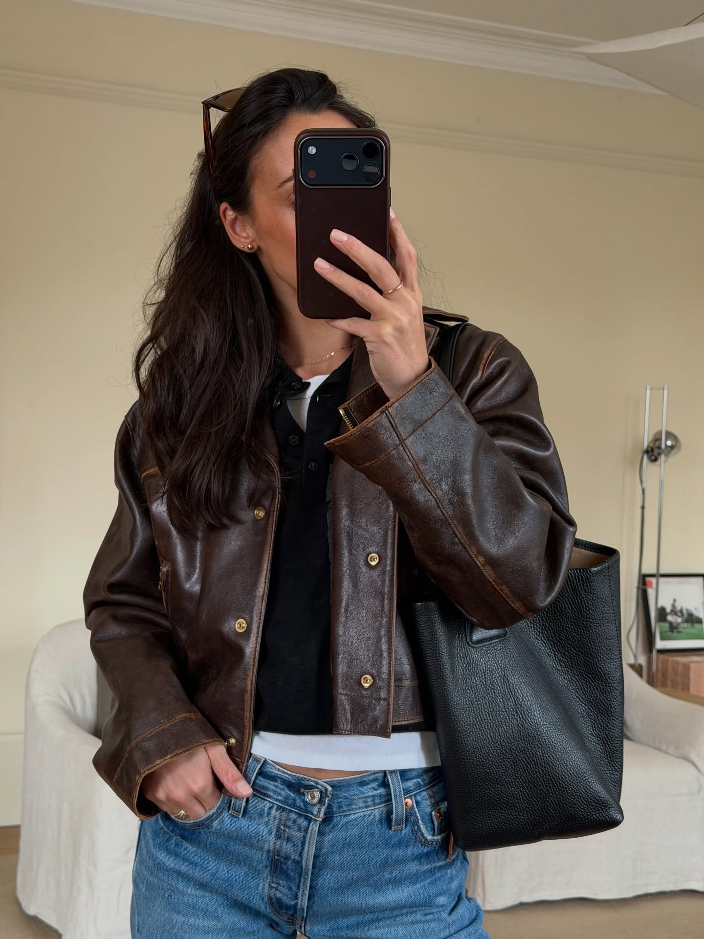 ems wells wears a leather jacket, jeans and a leather shoulder bag