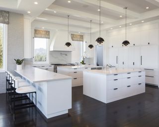 Modern white kitchen ideas with white double islands with black handles and black pendant lights