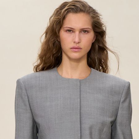 A model wearing a gray collarless blazer and matching skirt at the Calvin Klein F/W 25 show in New York.