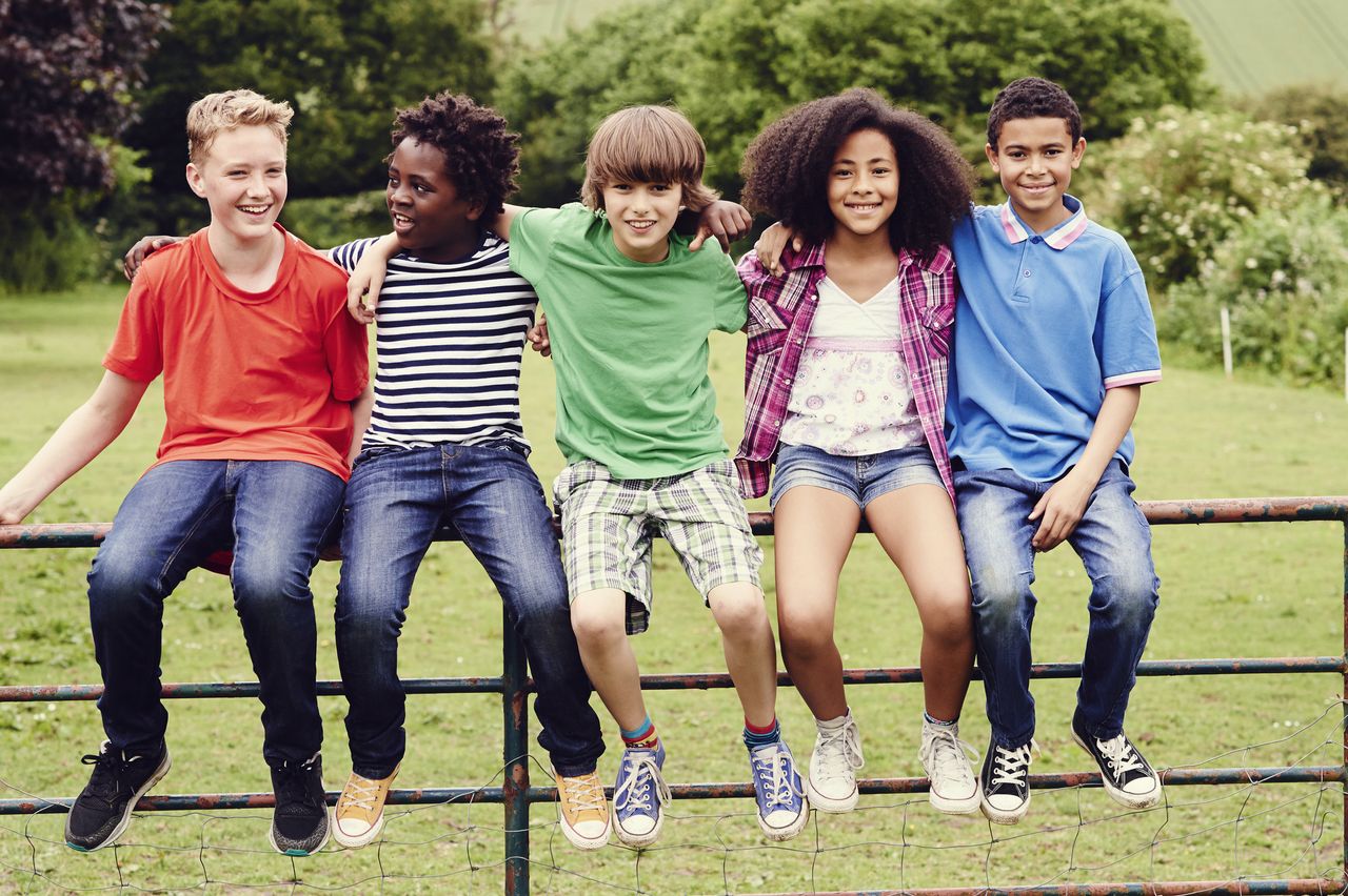 kids sitting on a fence