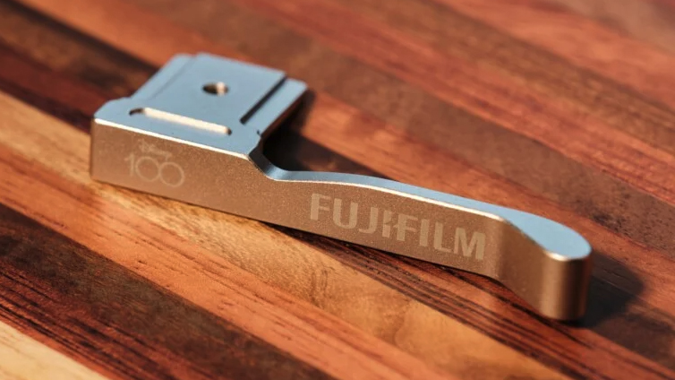 Disney-themed Fujifilm X100V camera thumb rest on a wooden table