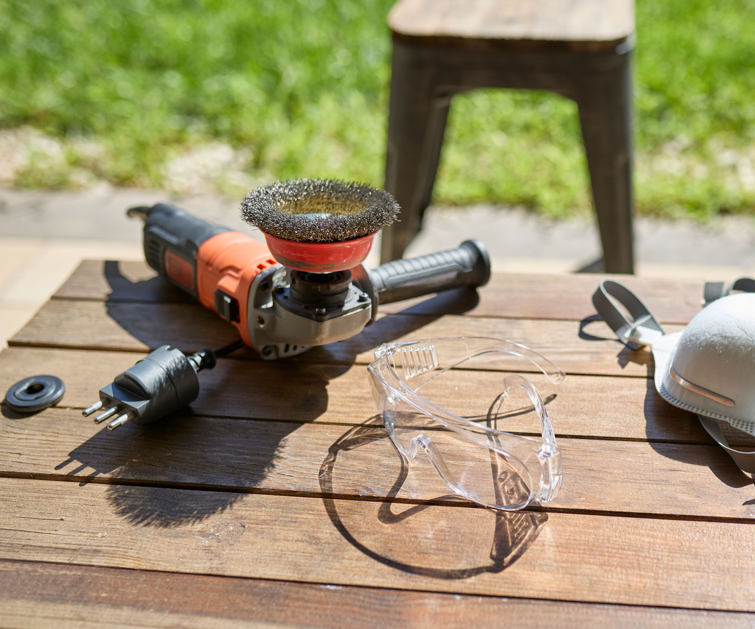 angle grinder on wooden table in sunshine