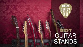 The headstocks of a variety of electric guitars and basses in a multi-guitar stand