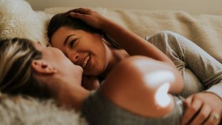 women cuddling and laughing in bed