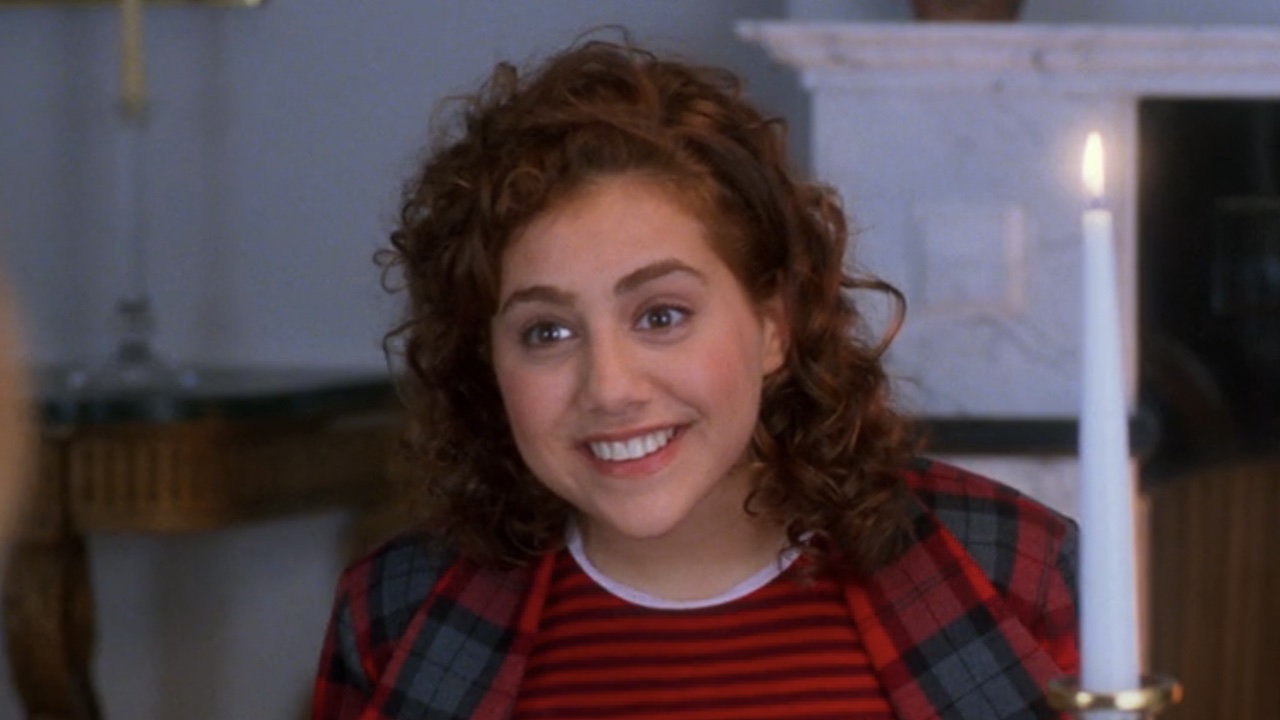 Brittany Murphy smiling at the dinner table in Clueless. 