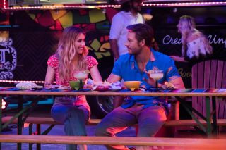 Emma Roberts and Luke Bracey sit next two each other at a mexican restaurant in 'Holidate"