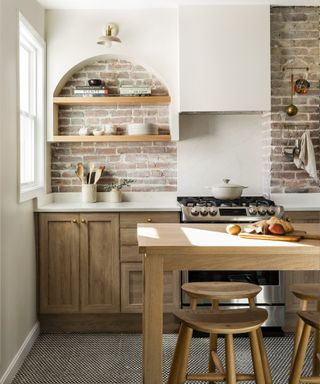 Modern rustic kitchen with exposed brick alcoves, wall shelving and wooden cabinets