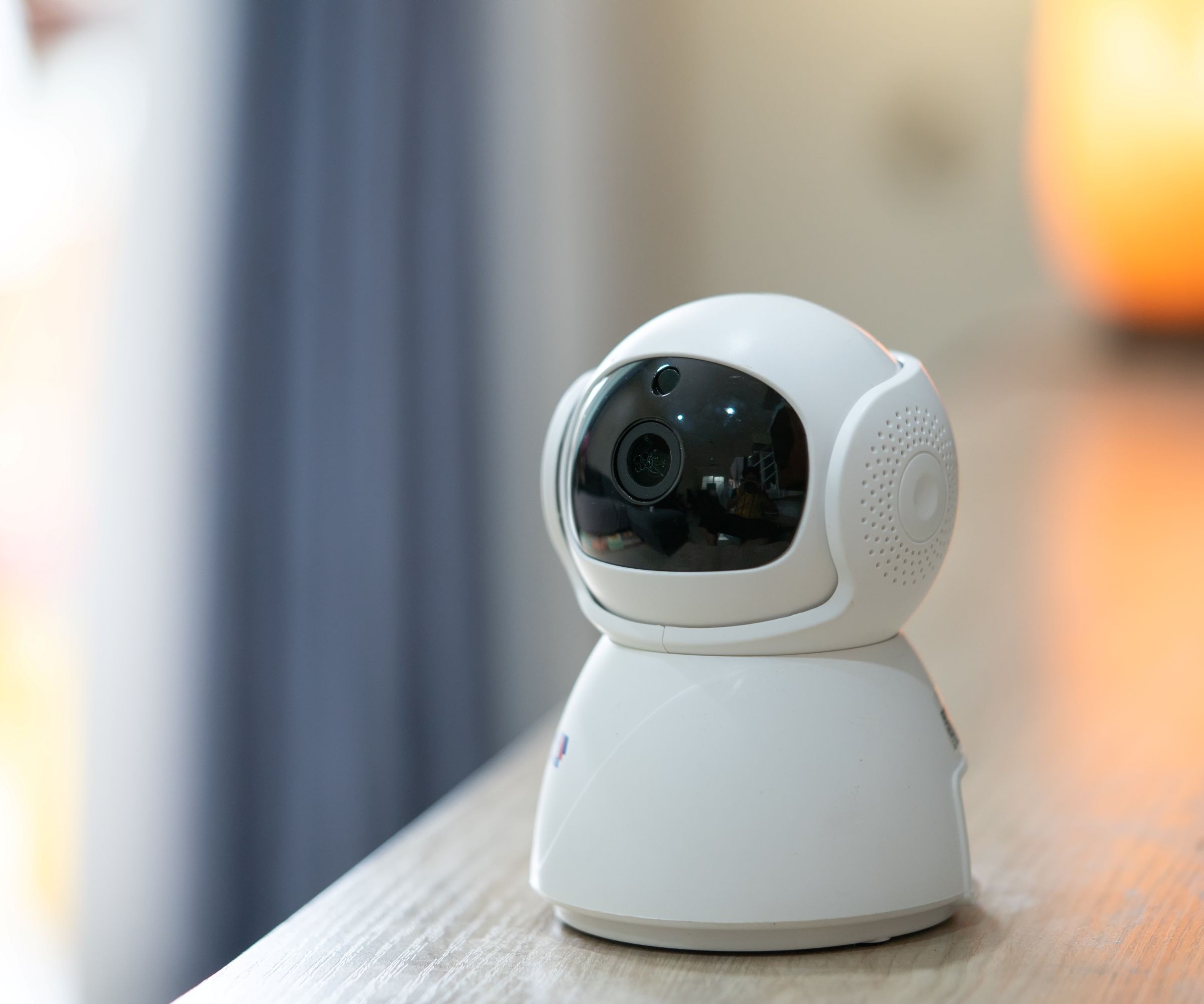 A security camera on a wooden table inside a home