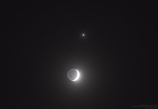 a thin crescent moon beside a pale yellow orb