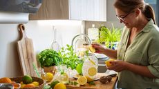 Woman in kitchen preparing fresh lemonade