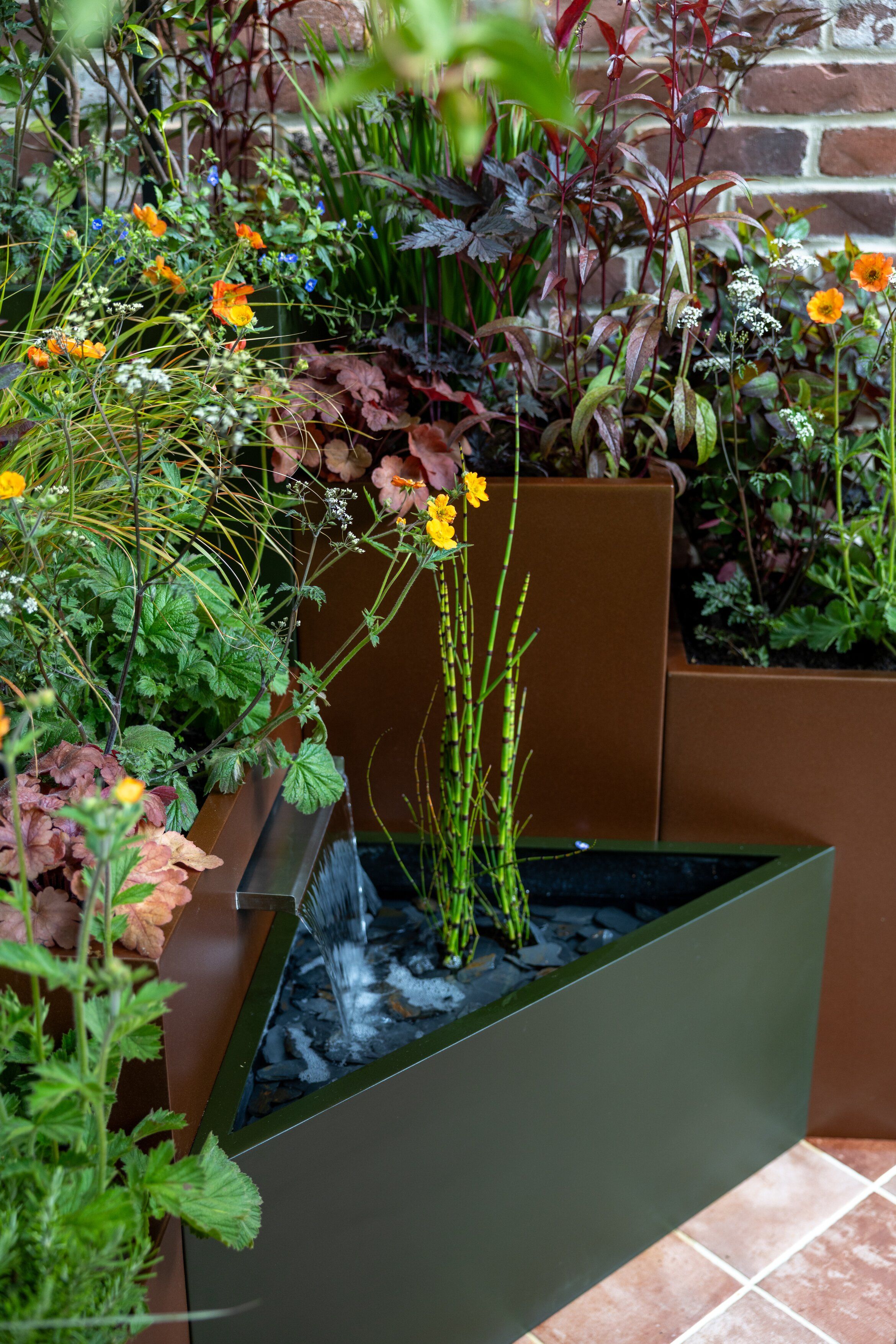 Images and details showing the planting and structure of the transient garden. Lots of brick, leafy greens and brushed metal