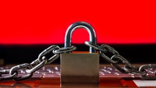 A chained lock situated on a laptop displaying a red screen