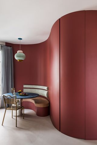 red curved wall with modern banquette seating
