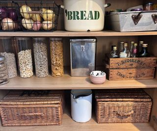 neat larder cupboard with glass storage jars and baskets