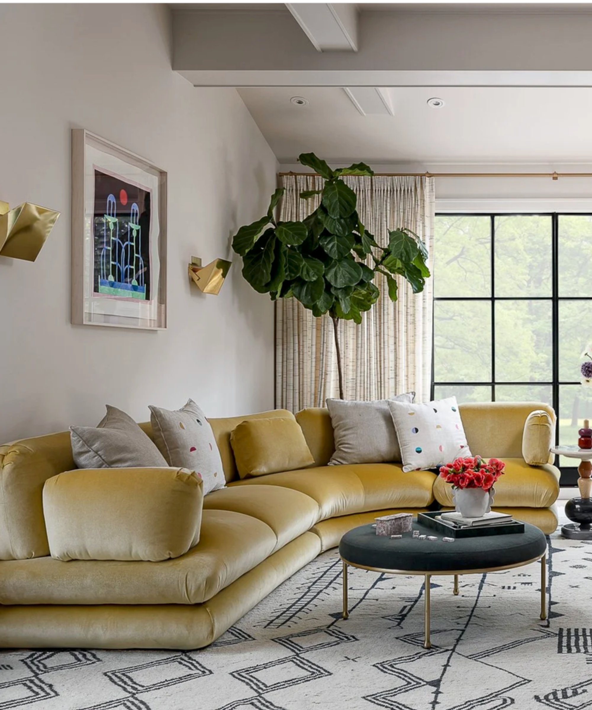 White living room with large yellow curved sofa in velvet