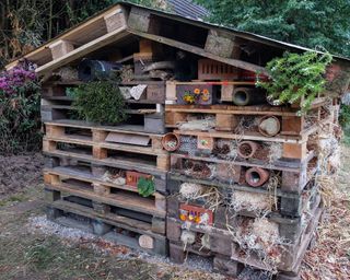 Large insect hotel made of pallets, perforated stones and many natural materials