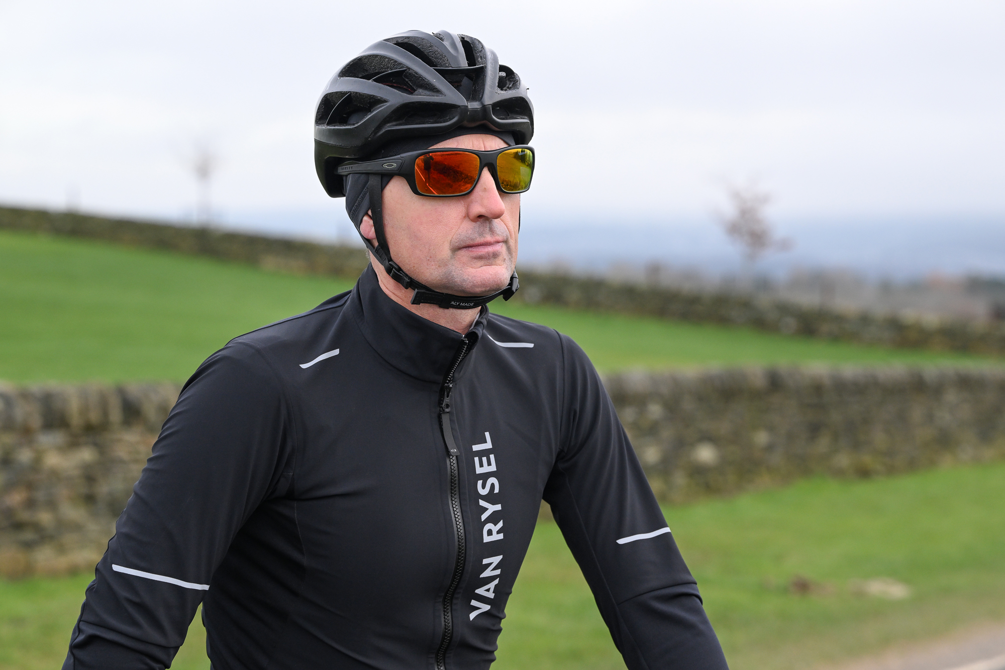 Man wearing a black jacket, black helmet and sunglasses