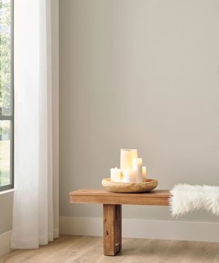 A light beige room with a wooden bench and a large window