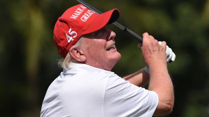 Donald Trump takes a shot before the 2022 LIV Golf Team Championship in Miami, Florida