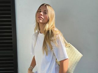 Sofia Richie in a white T-shirt and woven Bottega Veneta bag