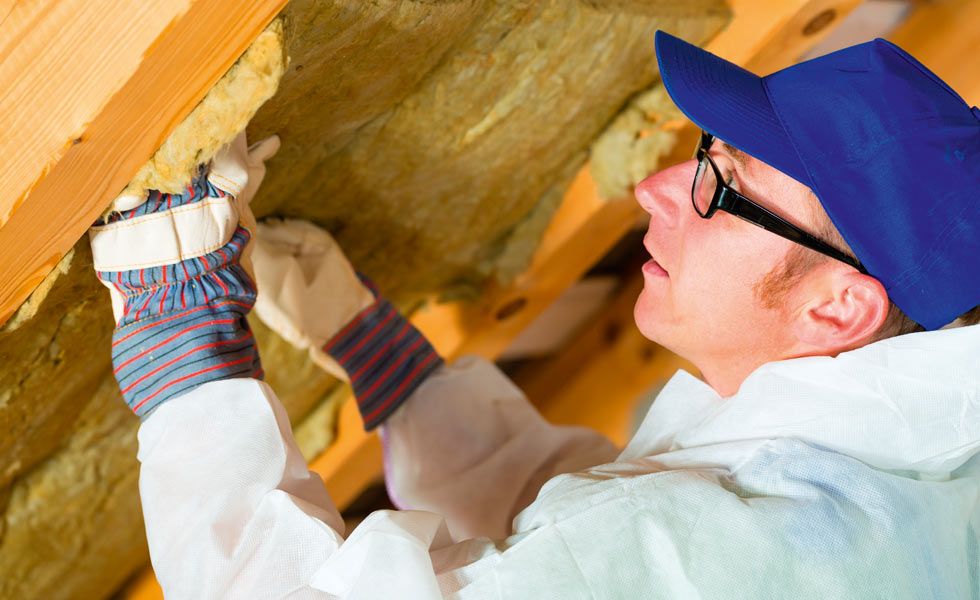 man applying insulation to roof