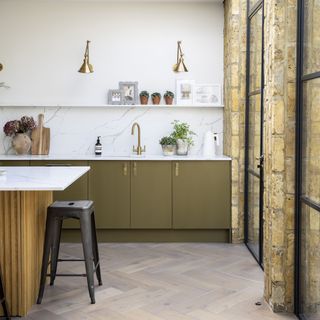 kitchen with marble tops and brass wall lights