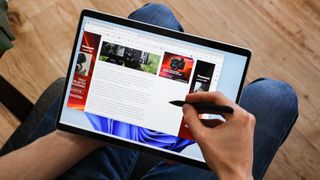person holding a microsoft surface pro 9, one of the best photo-editing laptops