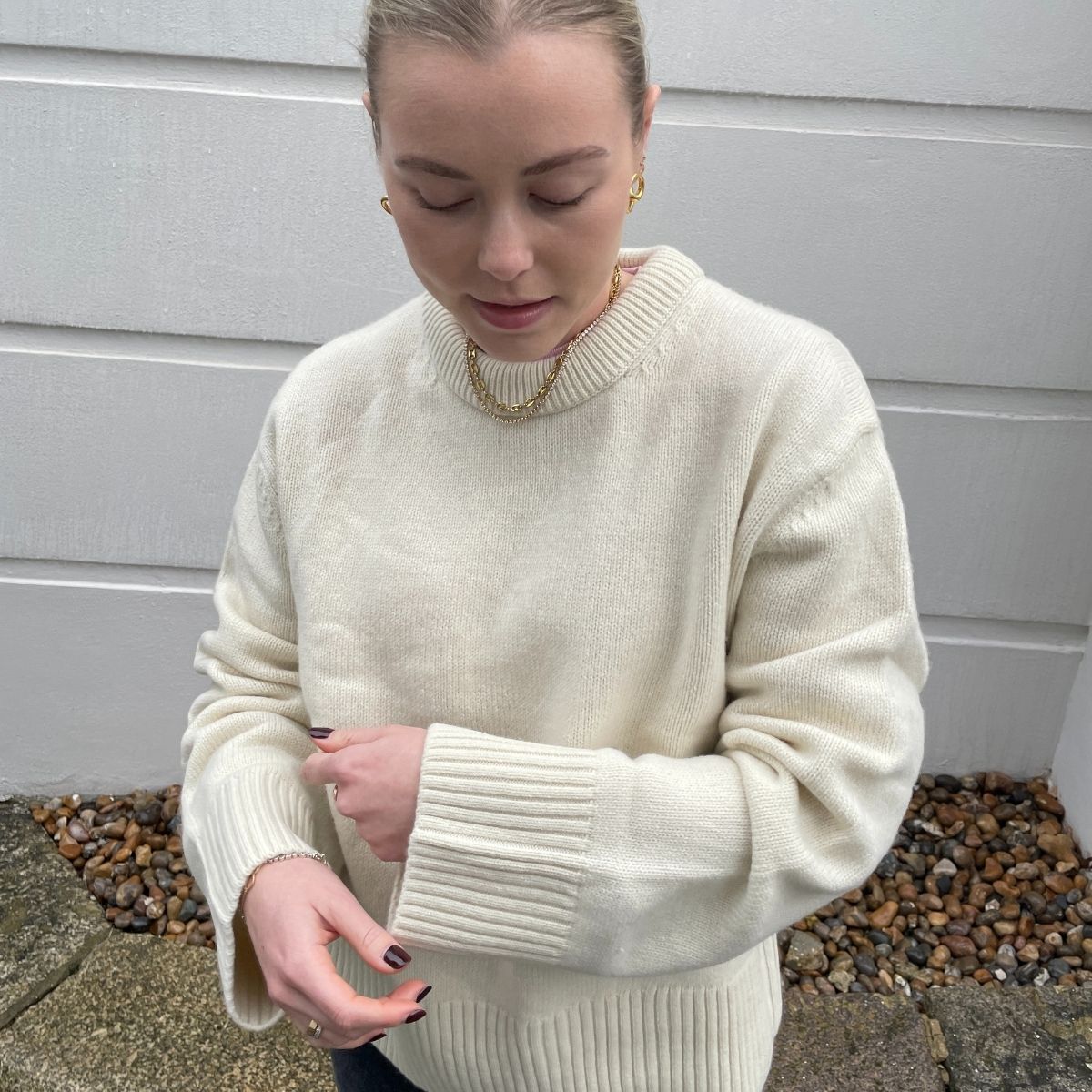 Woman wears cream jumper and black jeans