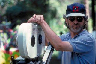 American director Steven Spielberg poses with a Panaflex camera on the set of the film 'Jurassic Park', 1993.